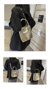 Détails d'un sac à main doré métallisé avec chaîne de perles et bandoulière réglable