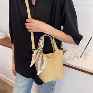 Fashionable yellow lychee leather bucket bag with printed silk scarf and crossbody strap