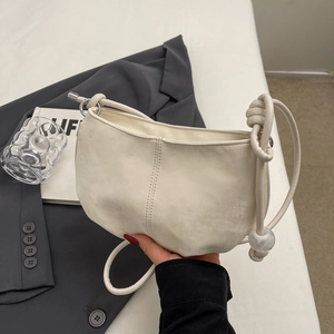 Minimalist beige half-moon crossbody bag with knotted strap and marble bead detail