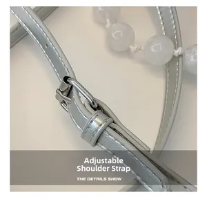 Detail of adjustable silver metallic PU shoulder strap with sleek buckle hardware