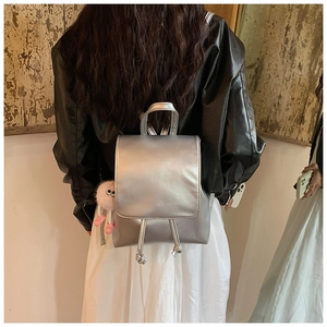 Silver PU leather backpack with drawstring closure and a pink plush charm detail
