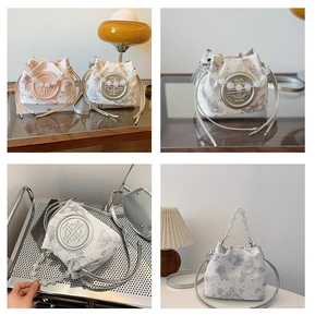 Detail of a white bucket bag with butterfly print and luxury pearl handle decoration