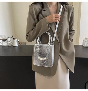 Détail du mini sac argenté avec chaîne en perles et texture métallique pour femmes