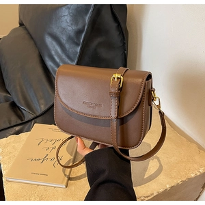 Dettaglio borsa a tracolla marrone retrò in pelle PU con logo impresso e fibbia oro