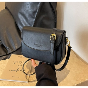 Dettaglio della piccola borsa a tracolla vintage nera con fibbia dorata elegante