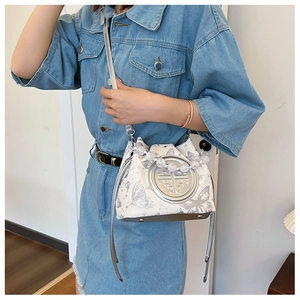 Detail of white bucket bag with silver butterfly print and pearl beaded handle