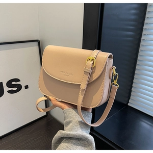 Dettaglio della piccola borsa a tracolla color nudo con finiture dorate e logo impresso