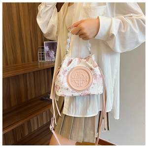 Detail of drawstring bucket bag with pink butterfly print and pearl beaded handle