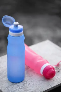 Detail of pink and blue collapsible silicone water bottles with metal carabiner clips