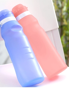 Macro view of blue and pink 600ml collapsible silicone sports bottles with scale markers