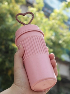 Pink collapsible silicone water bottle with brown heart handle and striped grip detail