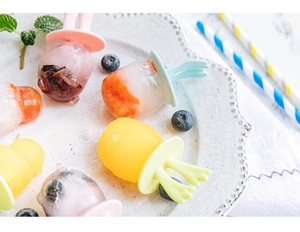 Détail de moules à glace en silicone avec boules de glace aux fruits sur assiette blanche
