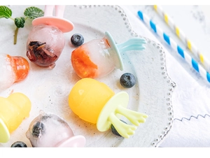 Détail de moules à glaces en silicone avec fruits frais et poignées colorées