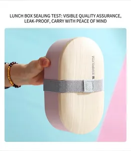 Close-up of portable oval lunch box with wood-style lid and elastic strap detail