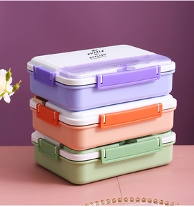 Trois boîtes à bento empilables en violet, rose et vert pastel avec couvercles à clips