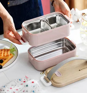 Close-up of pink stackable bento box with wood-textured lid and grey handle