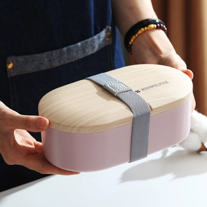 Pink oval wooden style lunch box with elastic strap and utensils for office or school
