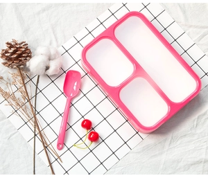 Detail view of pink 3-compartment bento box with matching spoon on textured background