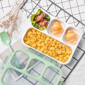 Three-compartment portable lunch box with lid and spoon in a minimalist green design