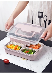 Close-up of a pink 4-compartment stainless steel lunch box with transparent lid and handle