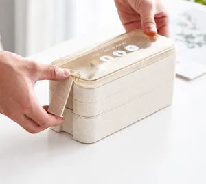 Detail showing the secure side buckle locking mechanism of the beige wheat straw lunch box