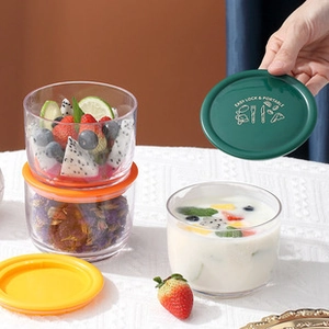 Close-up of clear glass storage containers with airtight colorful lids on lace cloth
