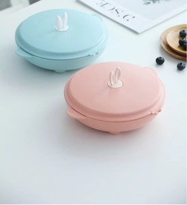 Detail of round kids lunch boxes with cute white bunny ear handles in blue and pink colors