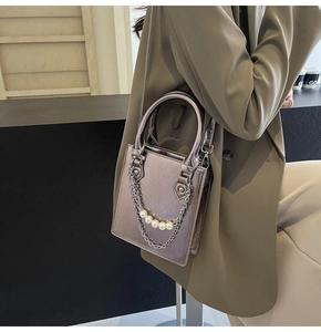 Détail d'un sac à bandoulière violet métallisé avec perles et chaîne argentée chic