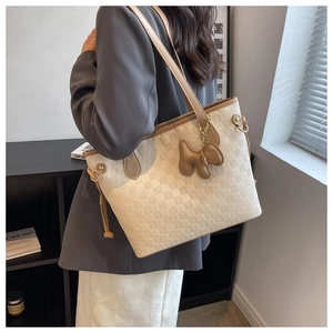 Détail du grand sac cabas beige tressé avec anses en cuir et charm chien décoratif