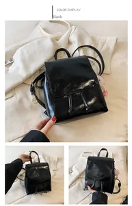 Detalle de mini mochila negra en cuero sintético brillante con borlas y cordón de moda