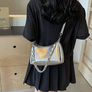 Sac à bandoulière chic en métal argenté avec texture plissée porté par un mannequin