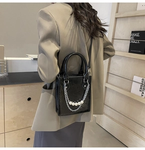 Détail du mini sac cabas en cuir verni brillant avec décorations perles et chaîne