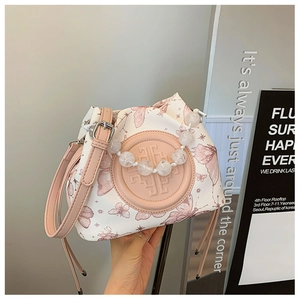 Detail of pink butterfly print bag with white pearl chain and elegant logo engraving