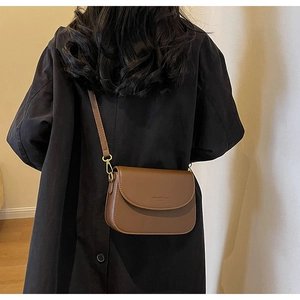 Dettaglio di una borsa a tracolla semitonda marrone scuro vintage con scritta dorata