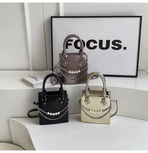 Vue détaillée des sacs carrés en cuir texturé avec chaîne en perles et accents métalliques