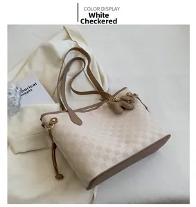 Détail du sac cabas à carreaux blancs avec anses marron et pendentif ours mignon