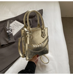 Vue détaillée du mini sac doré métallisé avec chaîne de perles et texture plissée