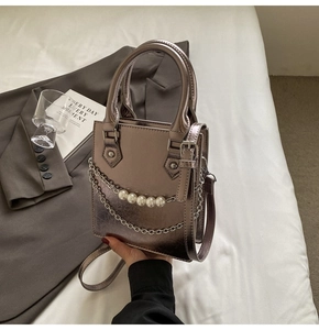 Détail du mini sac bronze métallisé avec chaîne à perles et finition miroir polie