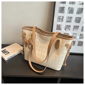 Détail du sac cabas à damier tissé avec poignées en cuir marron et cordon décoratif