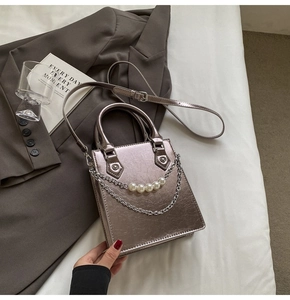Vue détaillée d'un sac à main métallique avec perles élégantes et accents de chaîne argentée