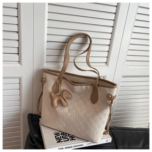 Détail de la texture damier tissée et des lanières contrastées sur un sac cabas beige