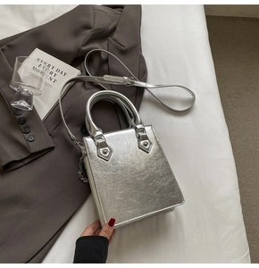 Vue détaillée du sac à main argenté en cuir métallisé avec chaîne perlée et bandoulière