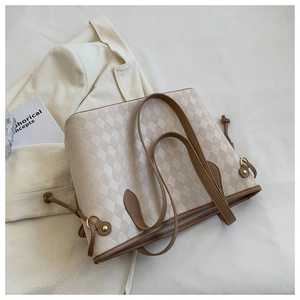 Détails du sac fourre-tout beige matelassé avec anses en cuir marron et cordons latéraux