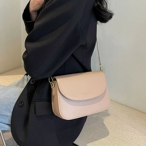 Borsa a tracolla beige minimalista con stampa fashion indossata da modella elegante
