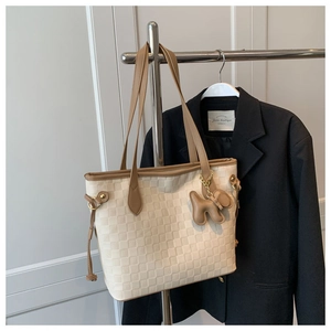 Détail du sac cabas tissé blanc cassé avec anses marron et pendentif chien mignon
