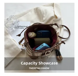 Interior view showing the large storage capacity of a plaid bucket bag with accessories