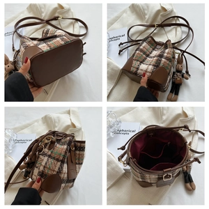 Detailed view of checkered tweed bucket bag showing interior pockets and rabbit charm