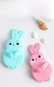 Close-up of cute rabbit-shaped silicone kitchen hooks in pastel green and pink colors