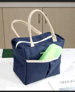 Détail du sac à déjeuner bleu marine isolé avec poignées en toile et poche frontale