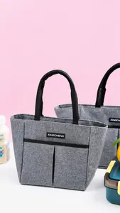 Gros plan du sac isotherme gris avec deux poches avant et des poignées de transport